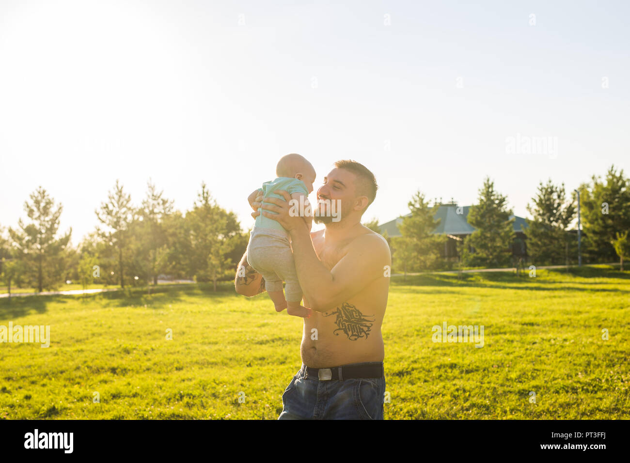 Happy father holding baby son, throwing baby in air. Concept of happy