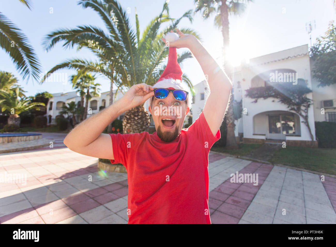 Christmas, holidays, humor, people concept - man take off the christmas hat from his head Stock Photo