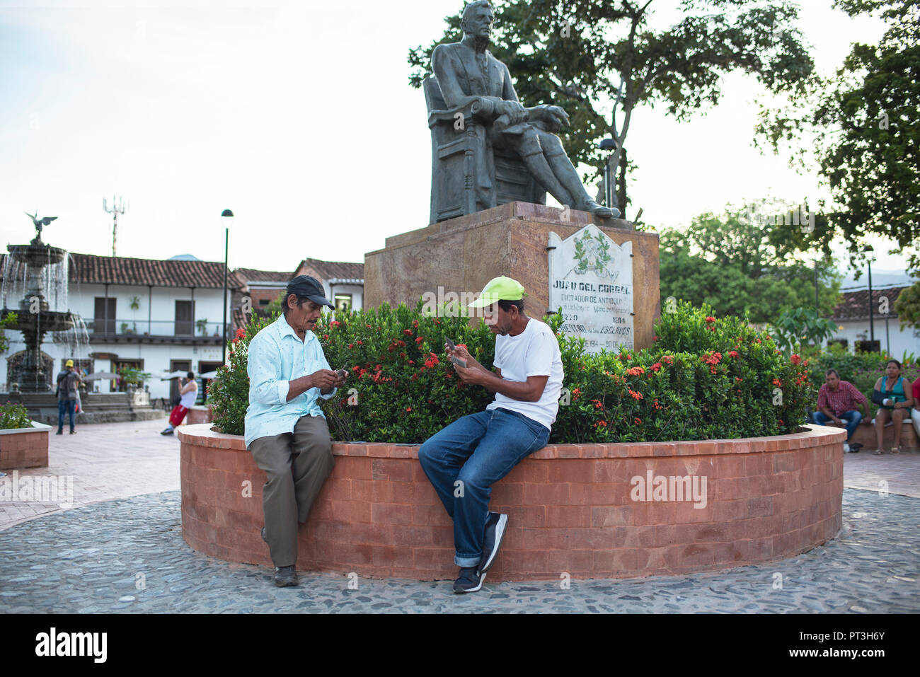 Men playing cards on Plaza de Bolivar in the colonial town of Santa Fe de Antioquia, Colombia. Sep 2018 Stock Photo