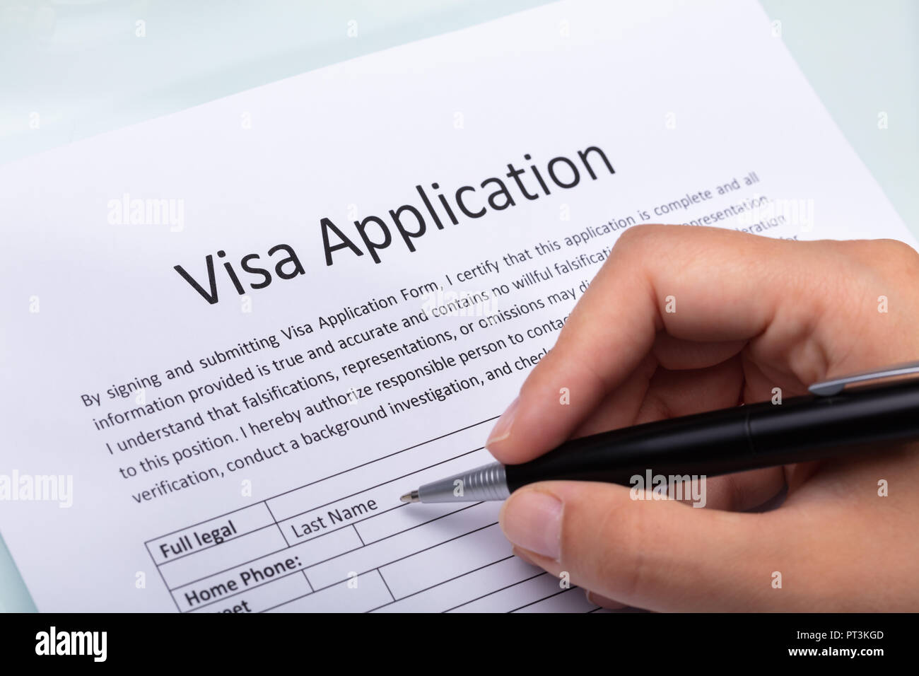 Close-up Of A Woman's Hand Filling Visa Application Form With Pen Stock Photo