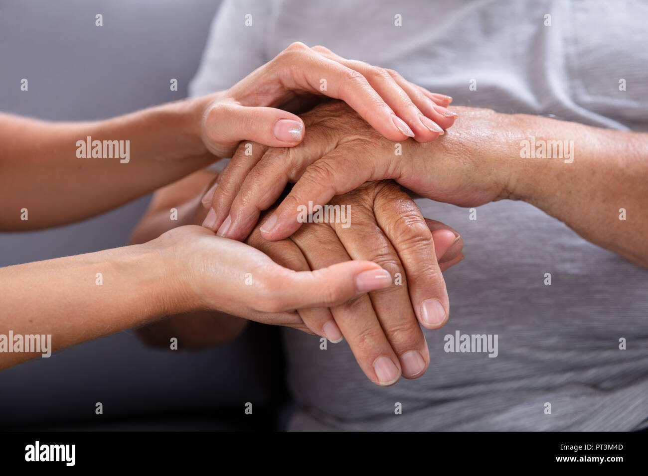 Close-up Of A Daughter Holding Her Elderly Father's Hand Stock Photo