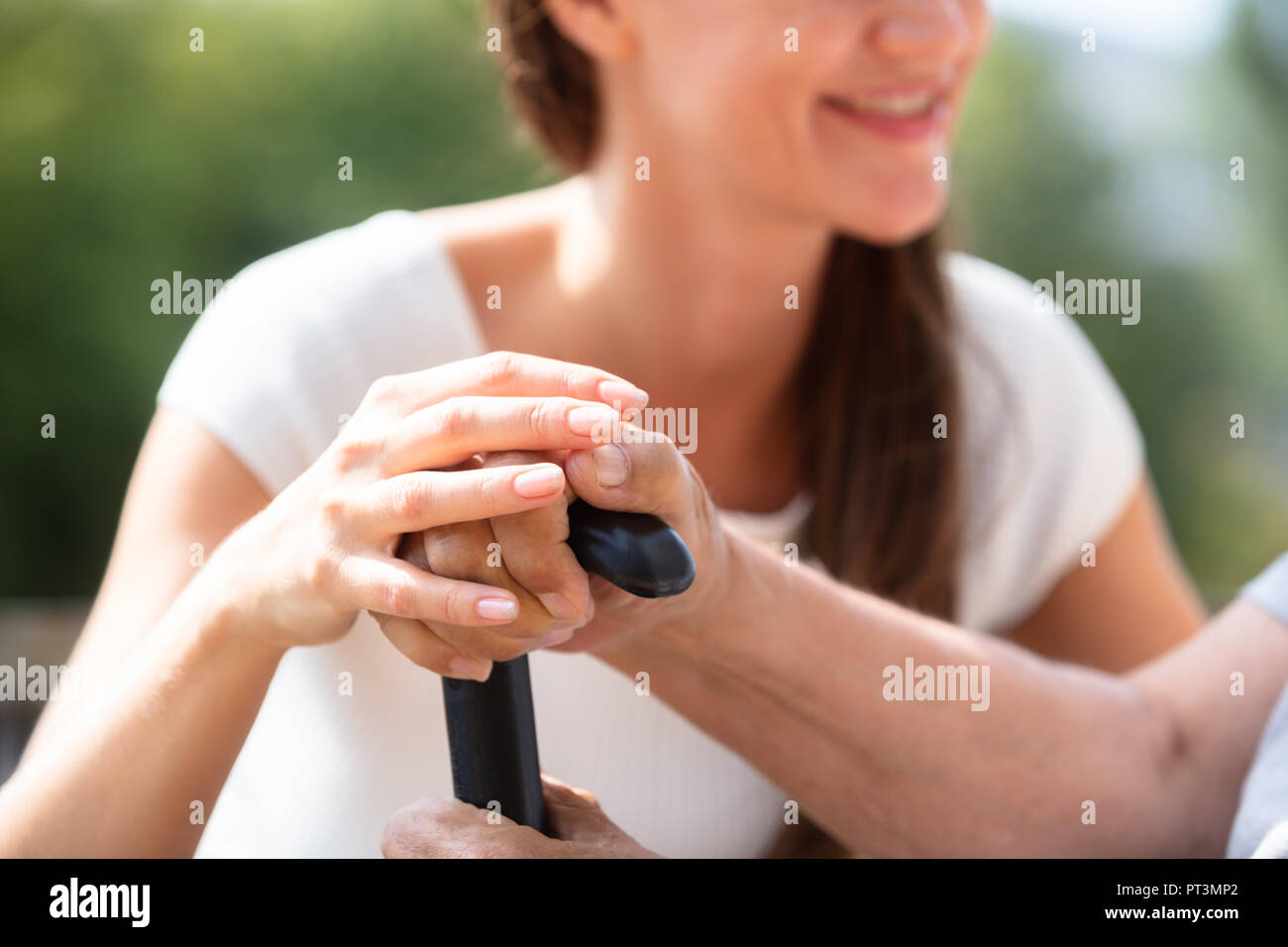 Closeup Of A Daughter's Hand Supporting Her Father Holding Walking