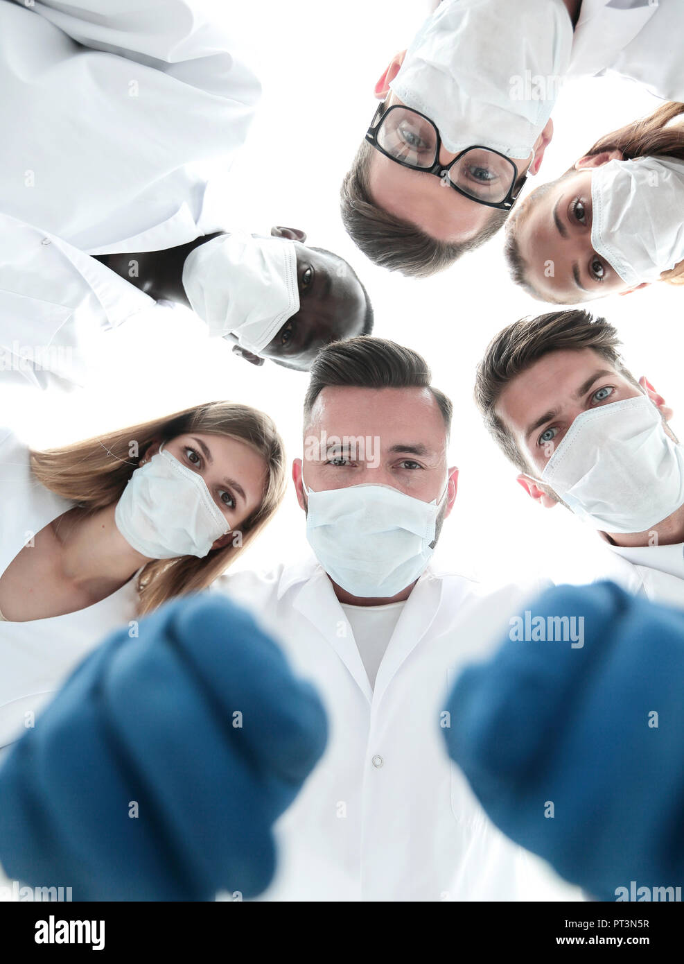 Team of medical professionals looking down at patient in surgical ...