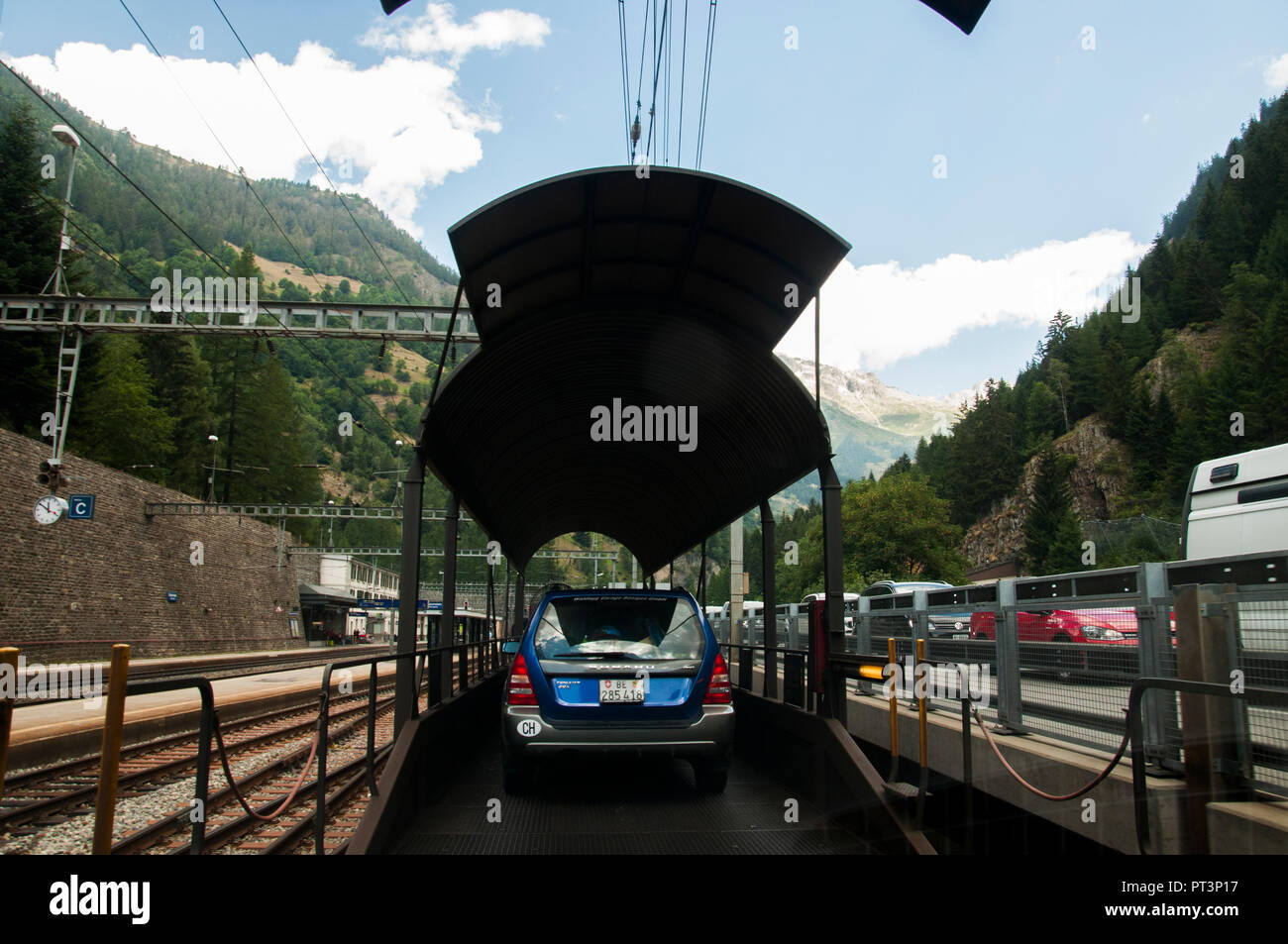 Cars loaded aboard the BLS car transport train which carries them through the Lötschberg Tunnel between Goppenstein and Kandersteg in the Swiss Alps Stock Photo