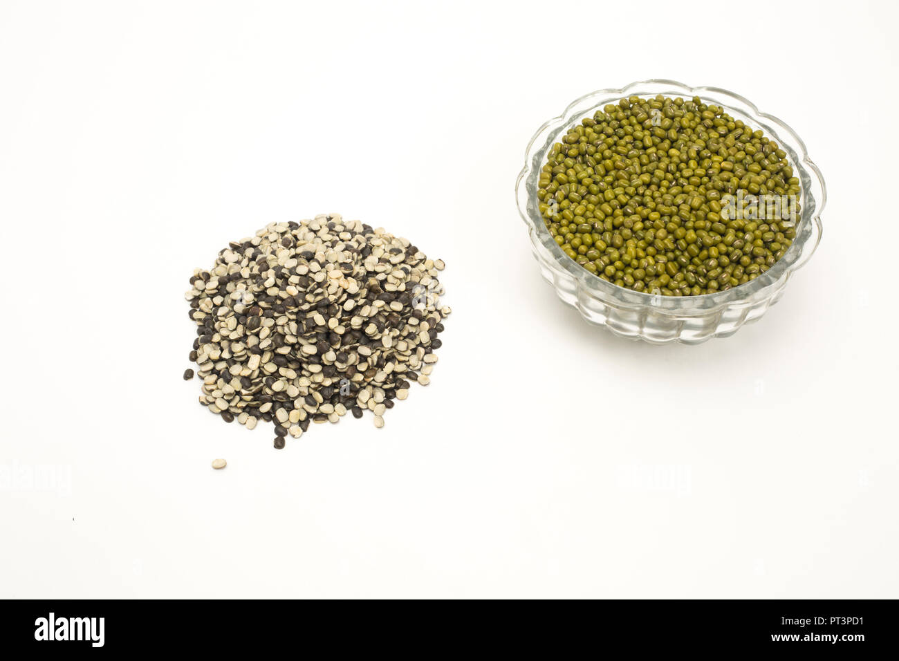 Green mung beans on glass bowl and split black lentil isolated on white