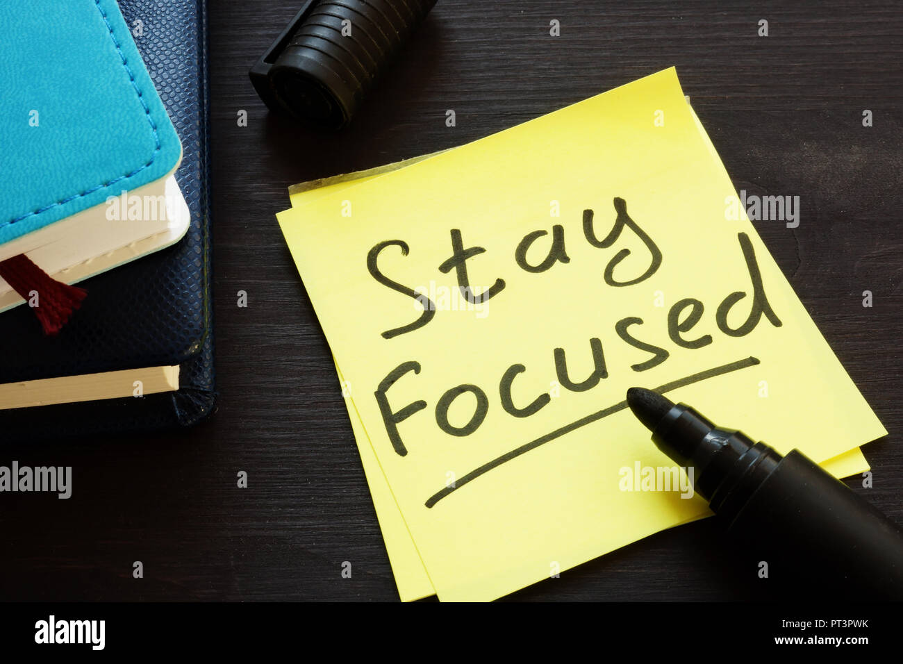 Stay focused handwritten on a memo stick and notepad. Stock Photo