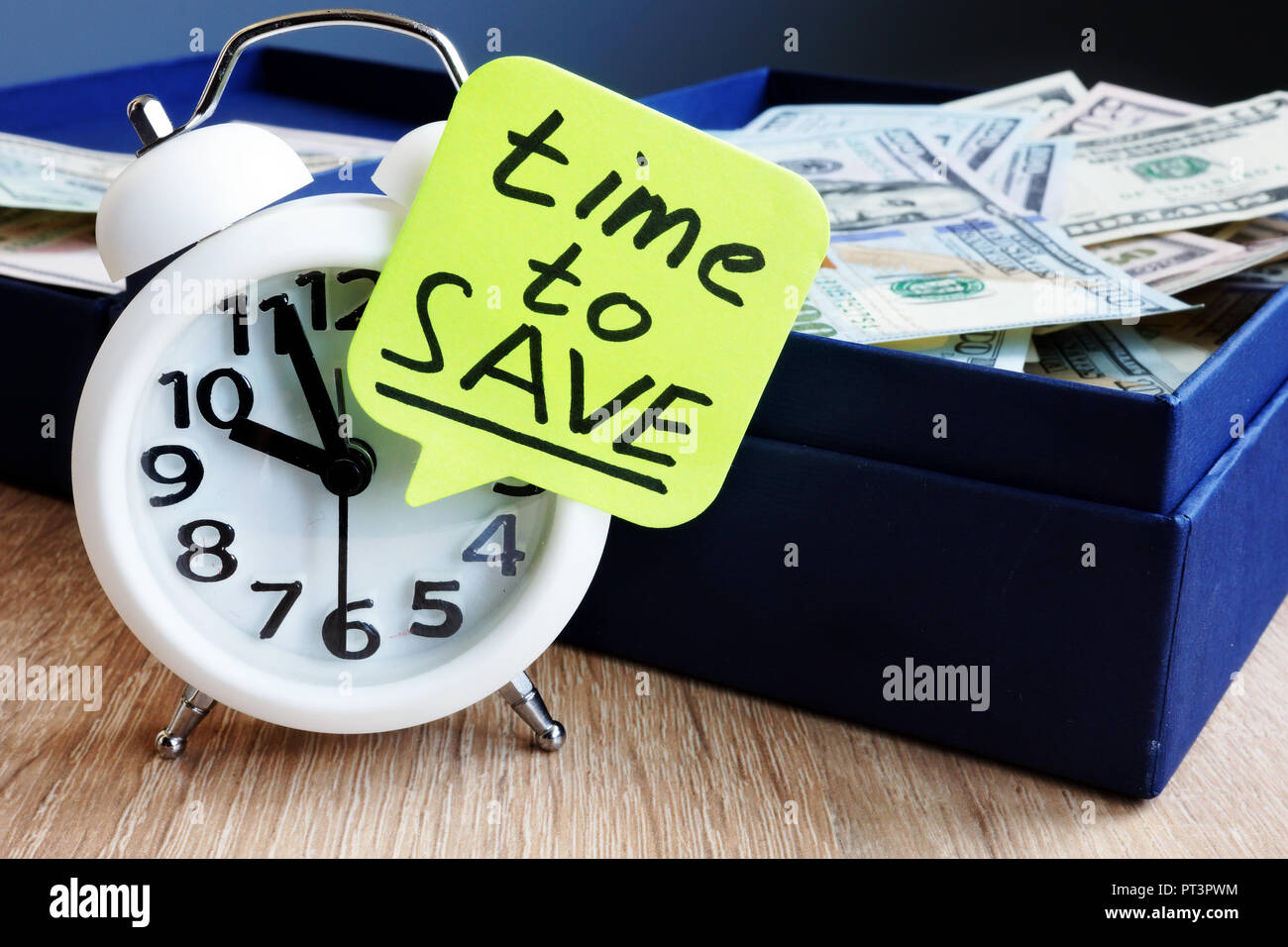 Time to Save. Alarm clock and money on a desk. Stock Photo
