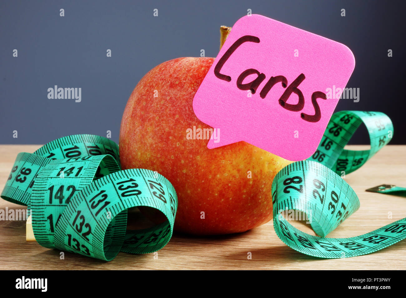 Carbs or Carbohydrates concept. Apple on a desk. Diets and healthy food. Stock Photo