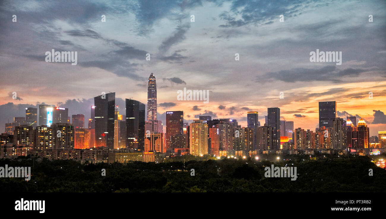 High-rise buildings in Futian District illuminated at dusk. Shenzhen, Guangdong Province, China. Stock Photo