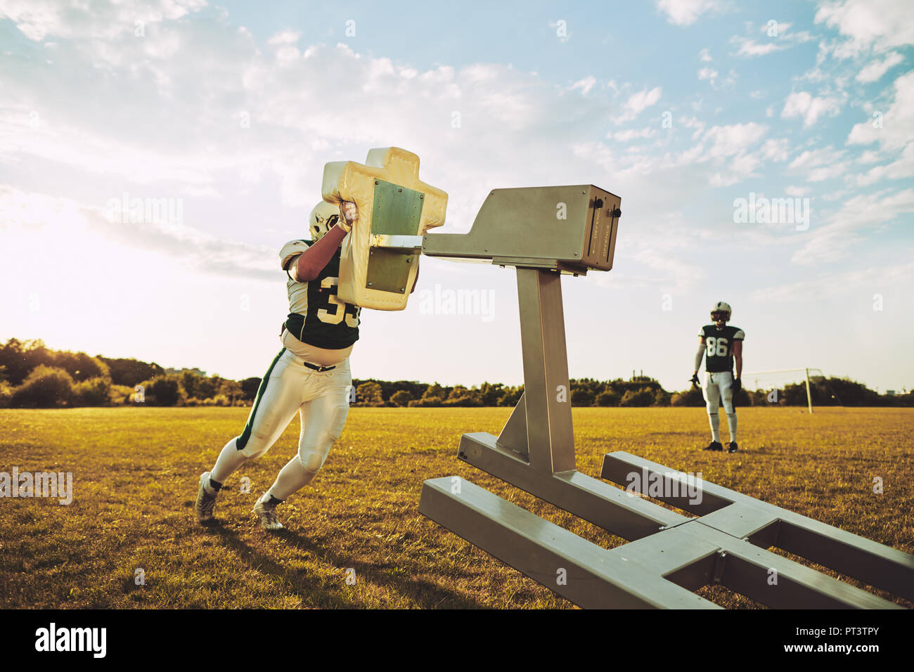 Two young American football player practicing tackles and defensive drills outside on a sports field in the afternoon Stock Photo