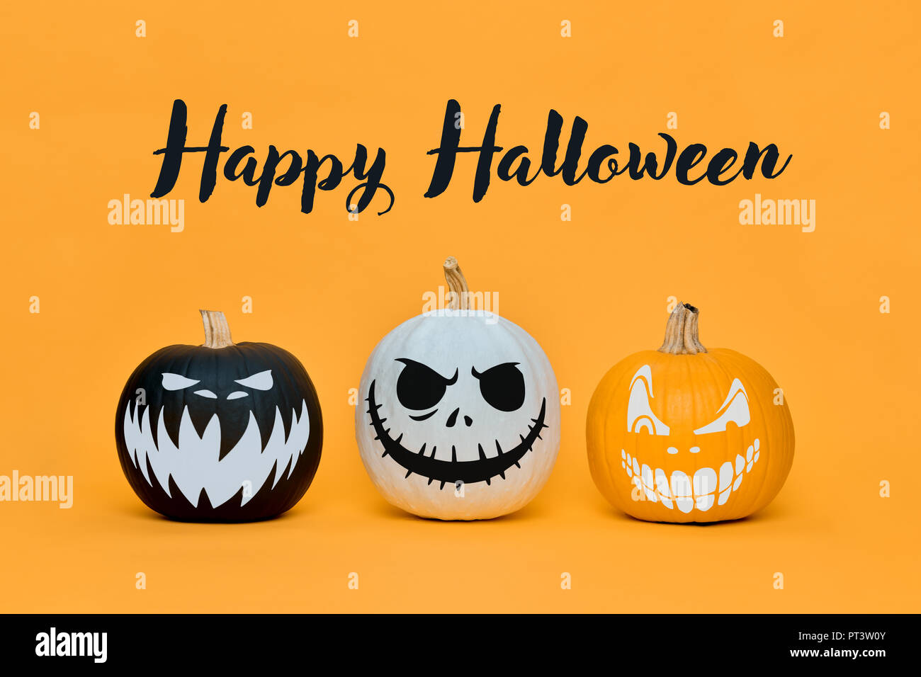 Three Spooky Halloween pumpkins with scary face expressions over orange ...