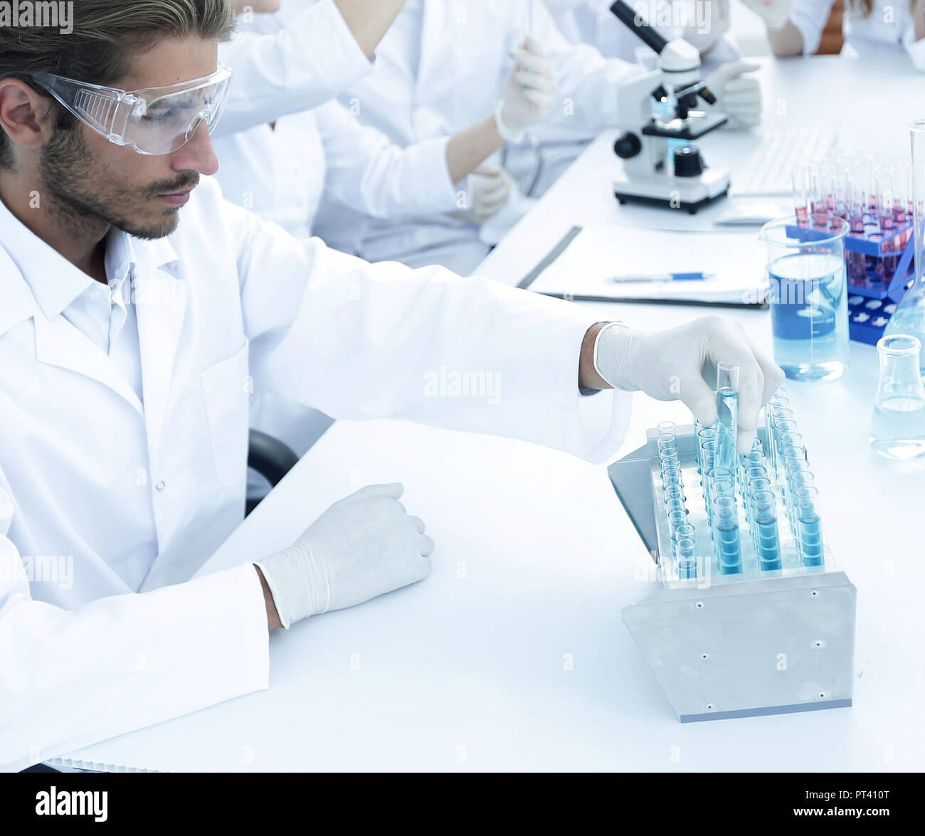 Scientists working with a microscope and make notes in the workplace in ...