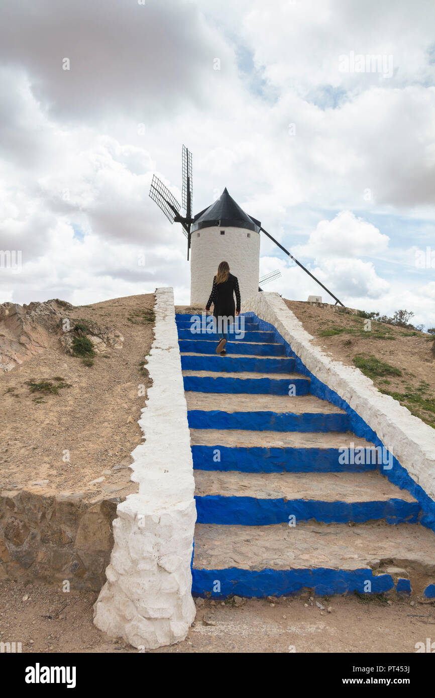 Woman on flight of steps towards windmill, Consuegra, Don Quixote route, Toledo province, Castile-La Mancha region, Spain Stock Photo