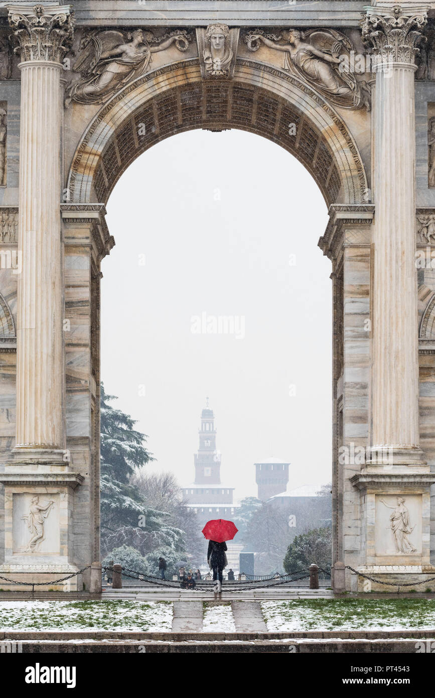 A woman with red umbrella admires the view of Sempione park during a snowfall, Milan, Lombardy, Italy, Europe, Stock Photo