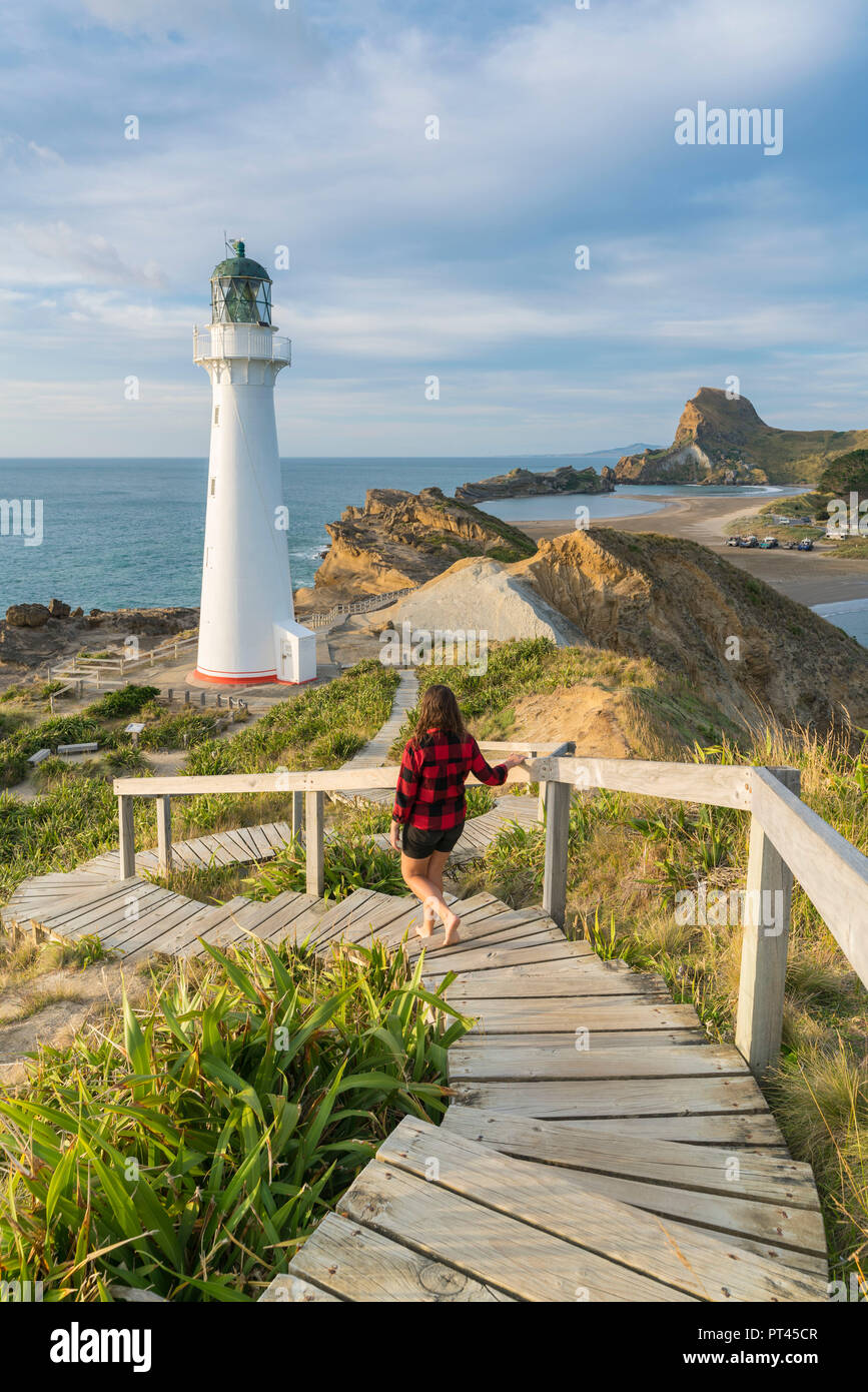 Woman descending the footpath towards Castlepoint lighthouse, Castlepoint, Wairarapa region, North Island, New Zealand, Stock Photo