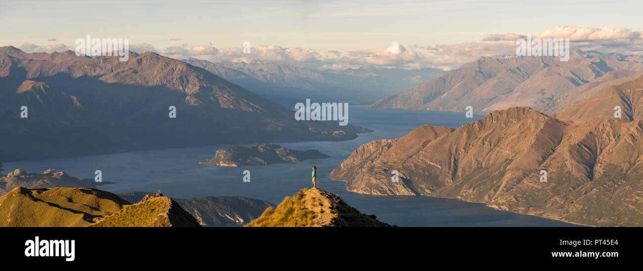 Woman admiring the landscape from Roys Peak lookout, Wanaka, Queenstown Lakes district, Otago region, South Island, New Zealand, Stock Photo