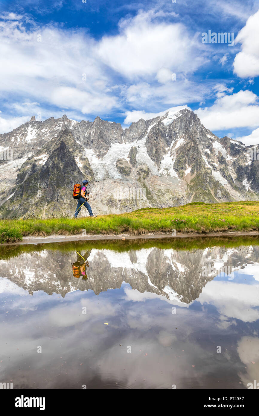 A trekker is walking on the Mont de la Saxe in front of Grandes Jorasses during the Mont Blanc hiking tours (Ferret Valley, Courmayeur, Aosta province, Aosta Valley, Italy, Europe) Stock Photo
