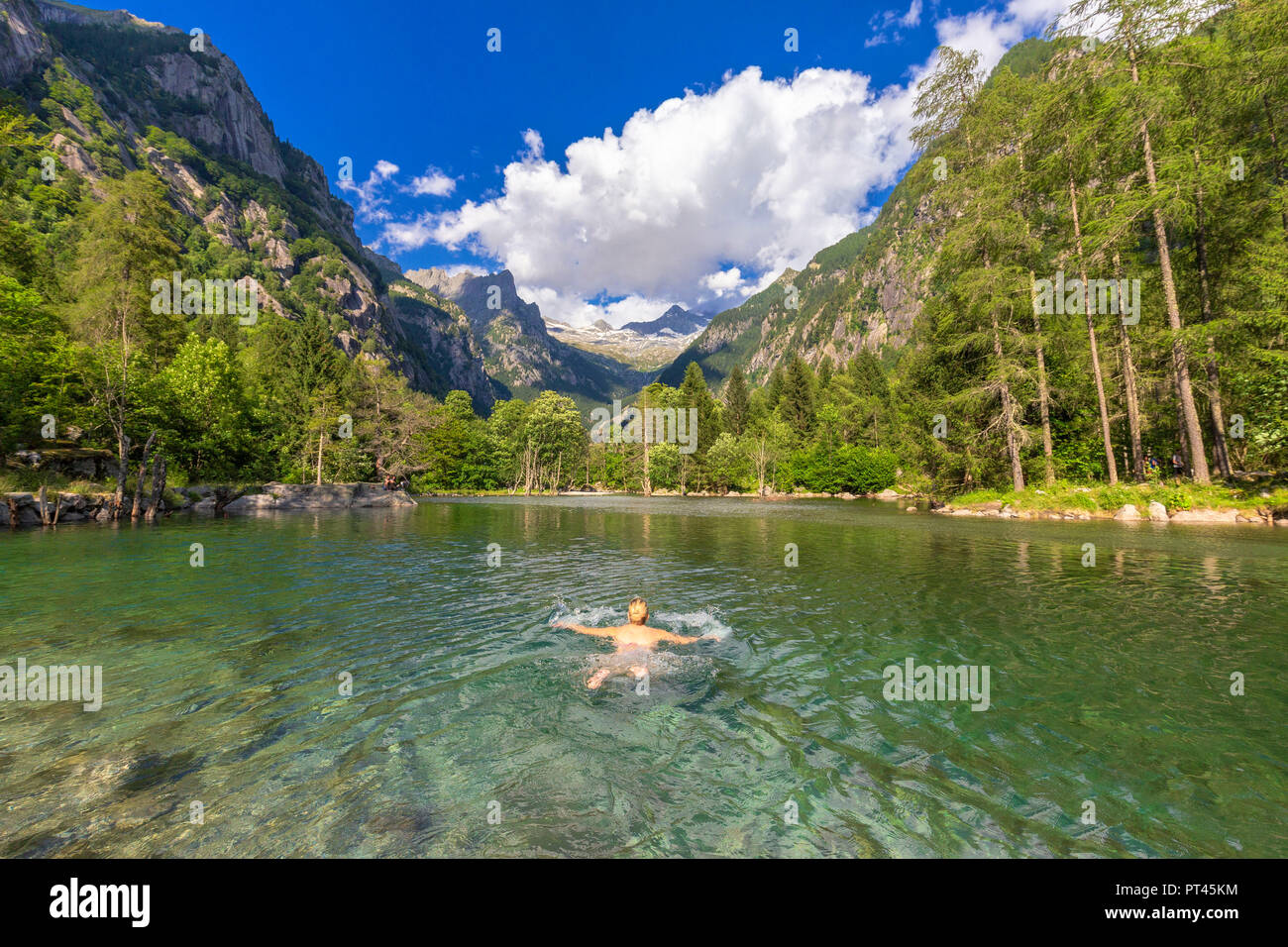 A girl swims in a clear alpine lake, Val di Mello (Mello Valley), Valmasino, Valtellina, Lombardy, Italy, Europe, Stock Photo