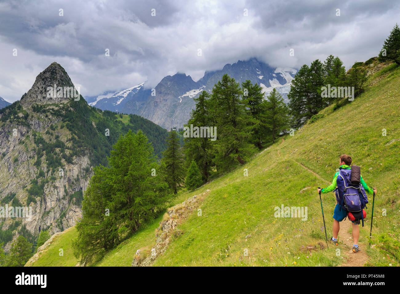 Hiker watches the threatening sky, Bertone Hut, Ferret Valley, Courmayeur, Aosta Valley, Italy, Europe Stock Photo