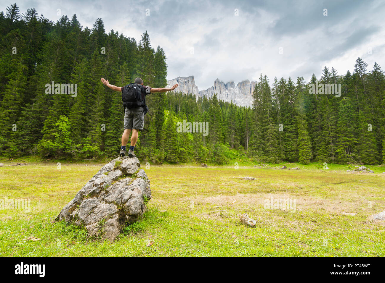 Hiker in the clearing of the middle lake of Carezza, Val d'Ega / Eggental, Dolomites, Province of Bolzano, South Tyrol, italian alps, Italy Stock Photo