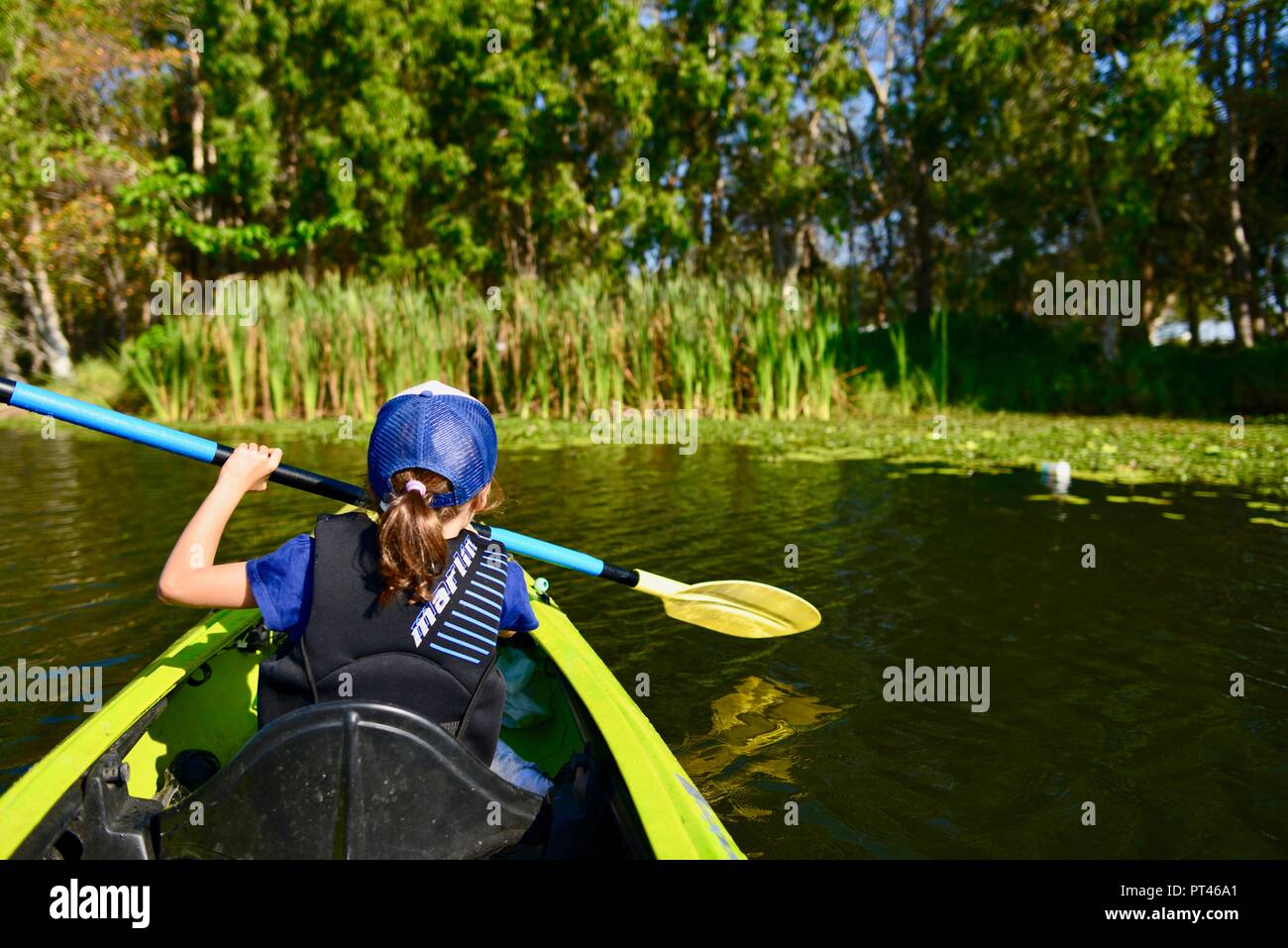 Children paddling in a canoe in beautiful weather, Ross River QLD