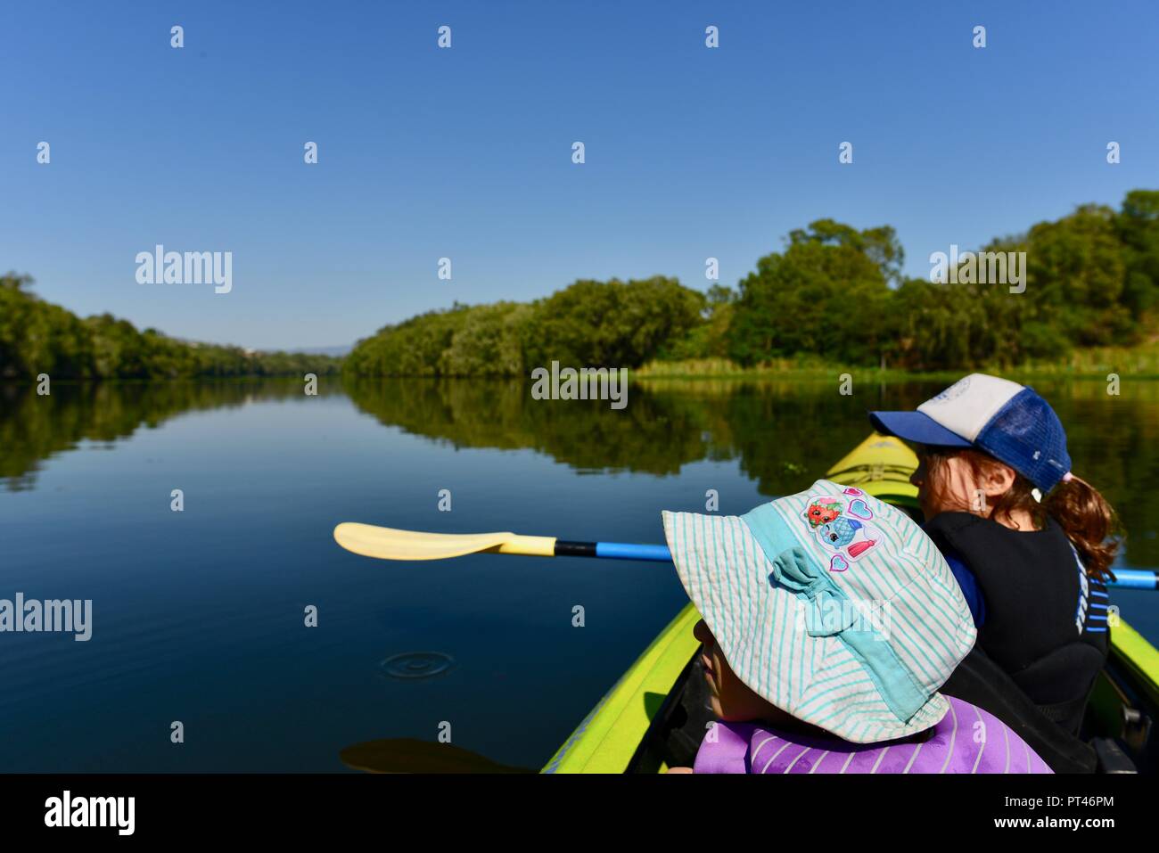 Children paddling in a canoe in beautiful weather, Ross River QLD