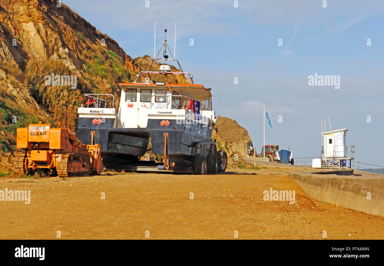 Fishing boats and lifeguards hut on high standing above the beach in North Norfolk at West Runton, Norfolk, England, United Kingdom, Europe. Stock Photo