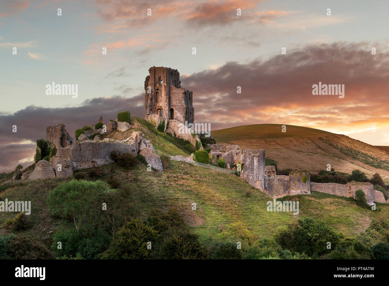 The sun lights up the ancient remains of Corfe Castle in Dorset. Stock Photo