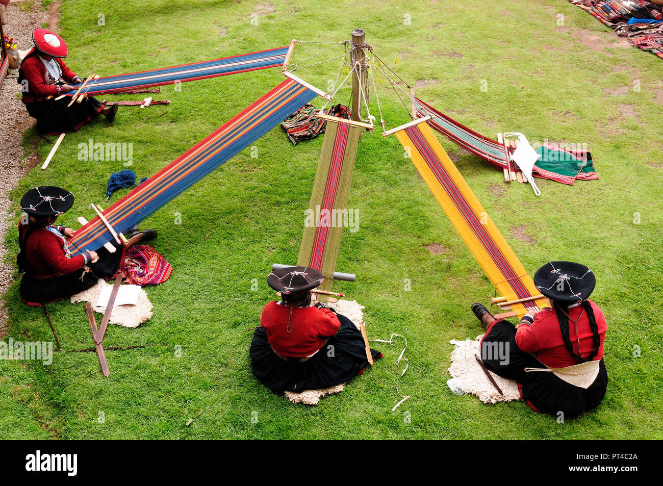 Female alpaca weavers weaving fabrics in the traditional way near Machu Picchu in Chincheros Stock Photo