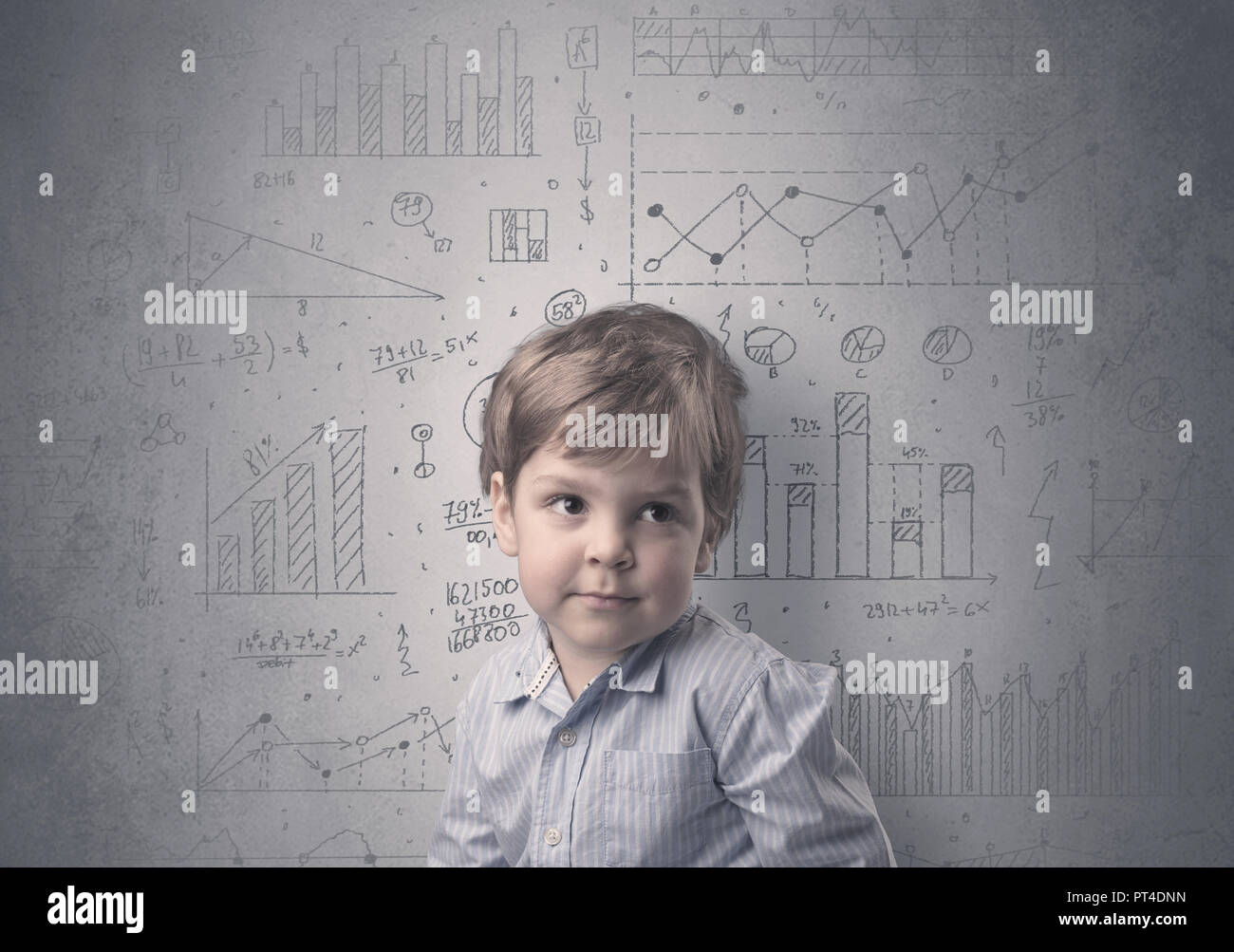 Little boy in front of a grey wall with graphs and statistics around ...