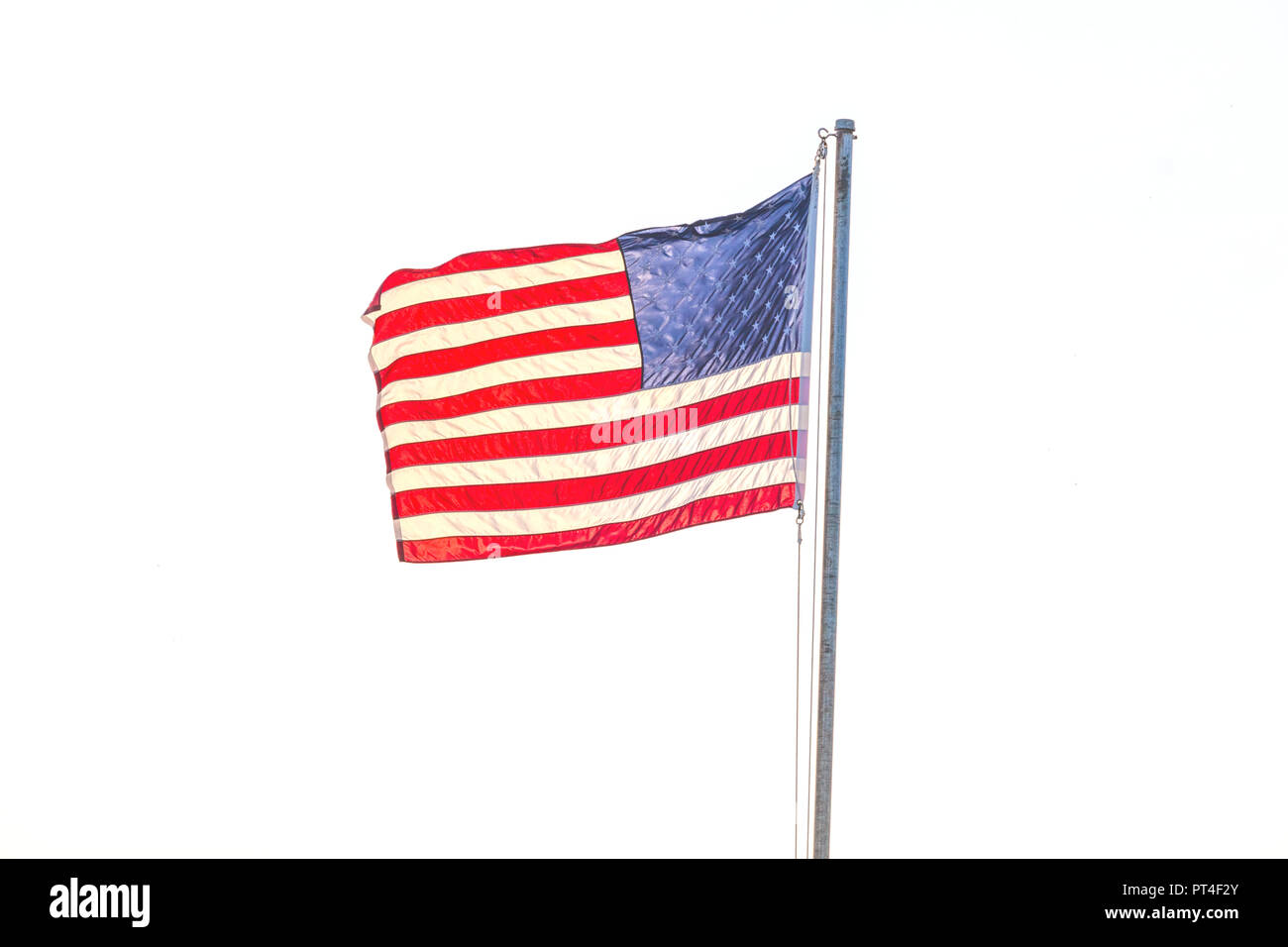 United States flag flying on a flag pole aganist a white background ...