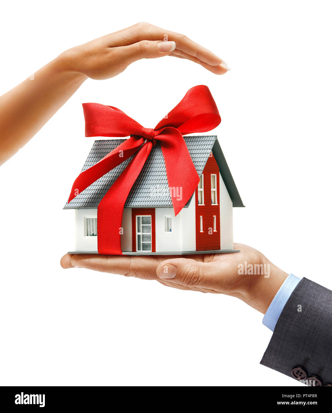 Man's hand in suit holding new house with red ribbon and woman's hand above cares about house isolated on white background. Close up. High resolution  Stock Photo