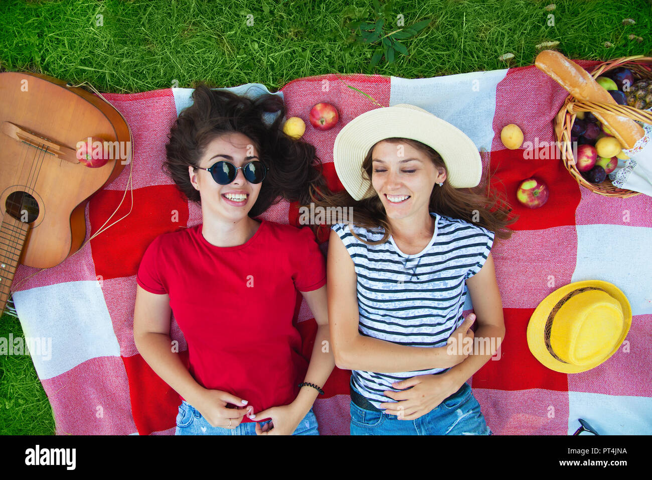 Two Beautiful Girls In Sunglasses Having Fun On A Picnic In The Forest