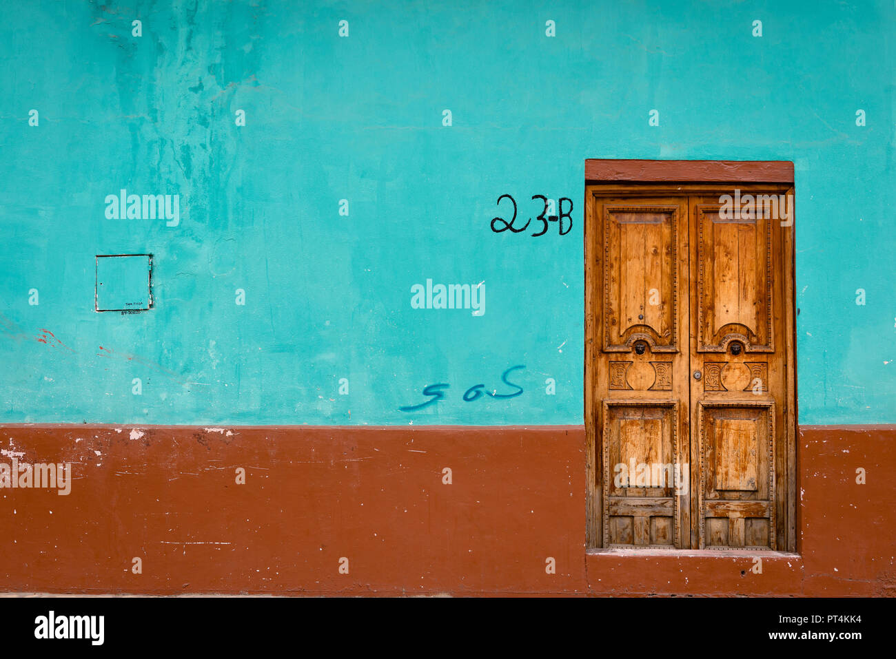 Ornate wooden door and colourful wall of a colonial style buildingin San Christobal, Mexico Stock Photo