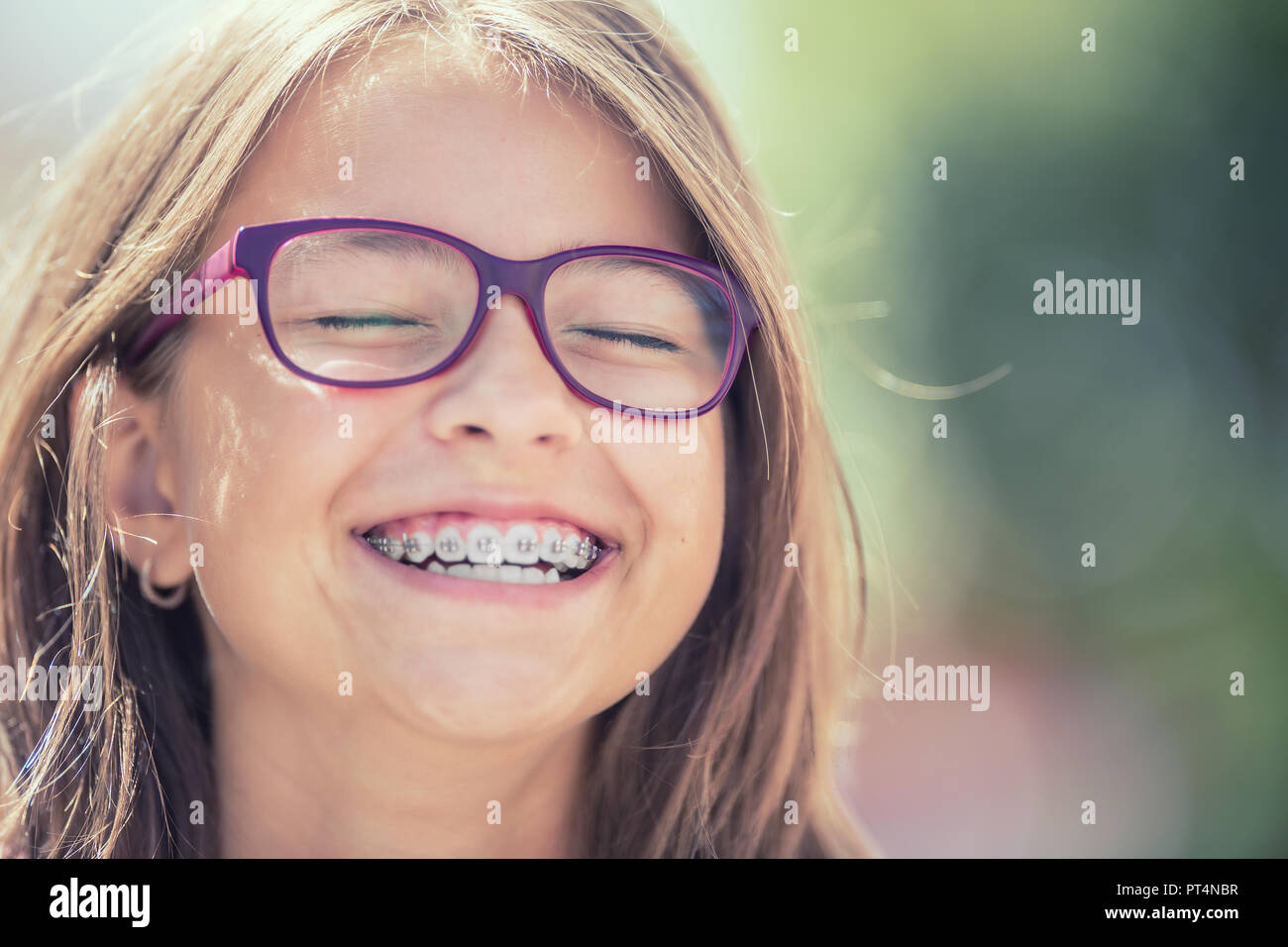 Portrait of a happy smiling teenage girl with dental braces and glasses