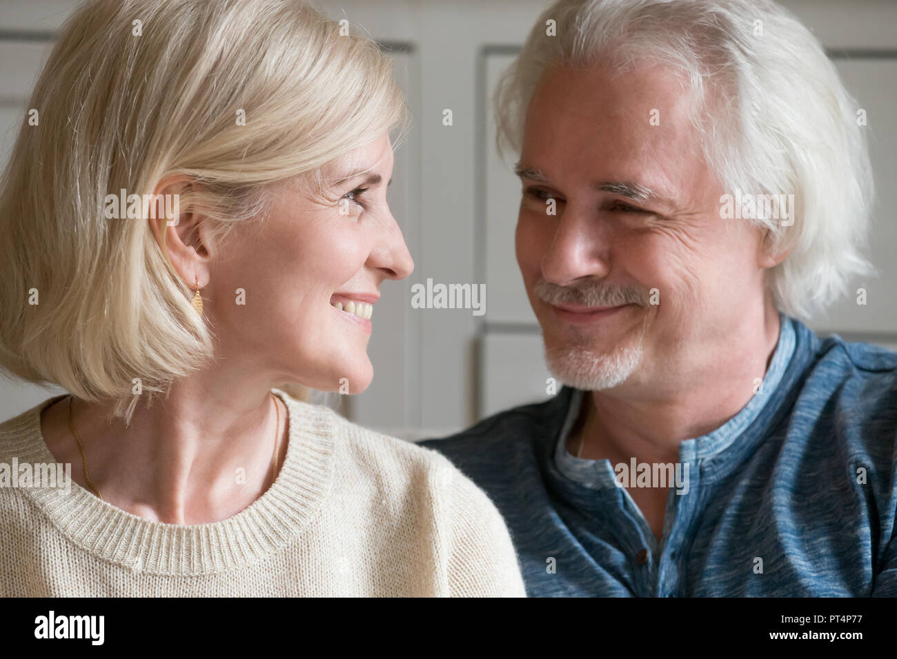 Smiling loving mature senior man and woman looking at each other enjoying true sincere feelings and good relations in marriage, happy middle aged roma Stock Photo