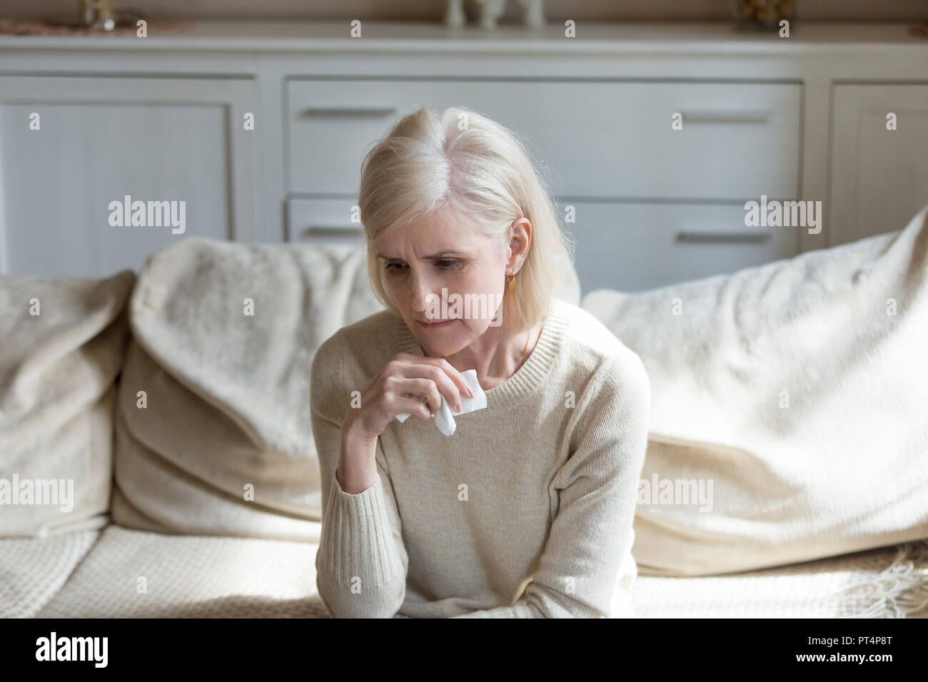 Sad lonely middle aged woman crying holding handkerchief, grievi Stock Photo