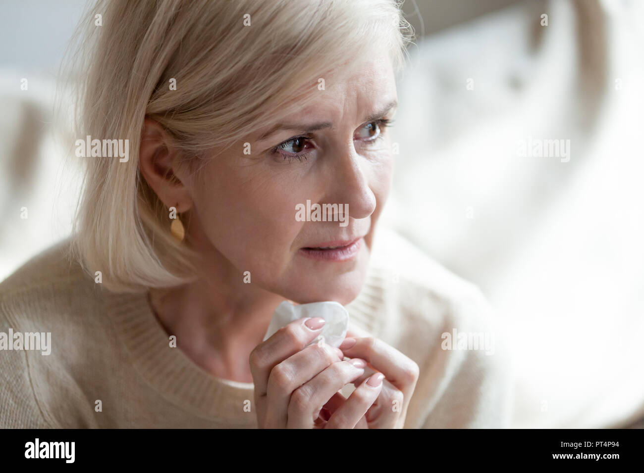 Sad frustrated middle aged woman in tears thinking of loneliness Stock Photo