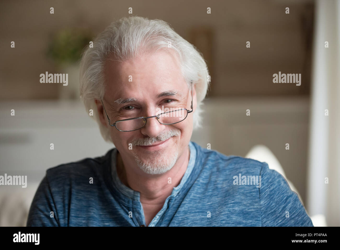 Charming middle aged grey haired man looking at camera, portrait Stock Photo
