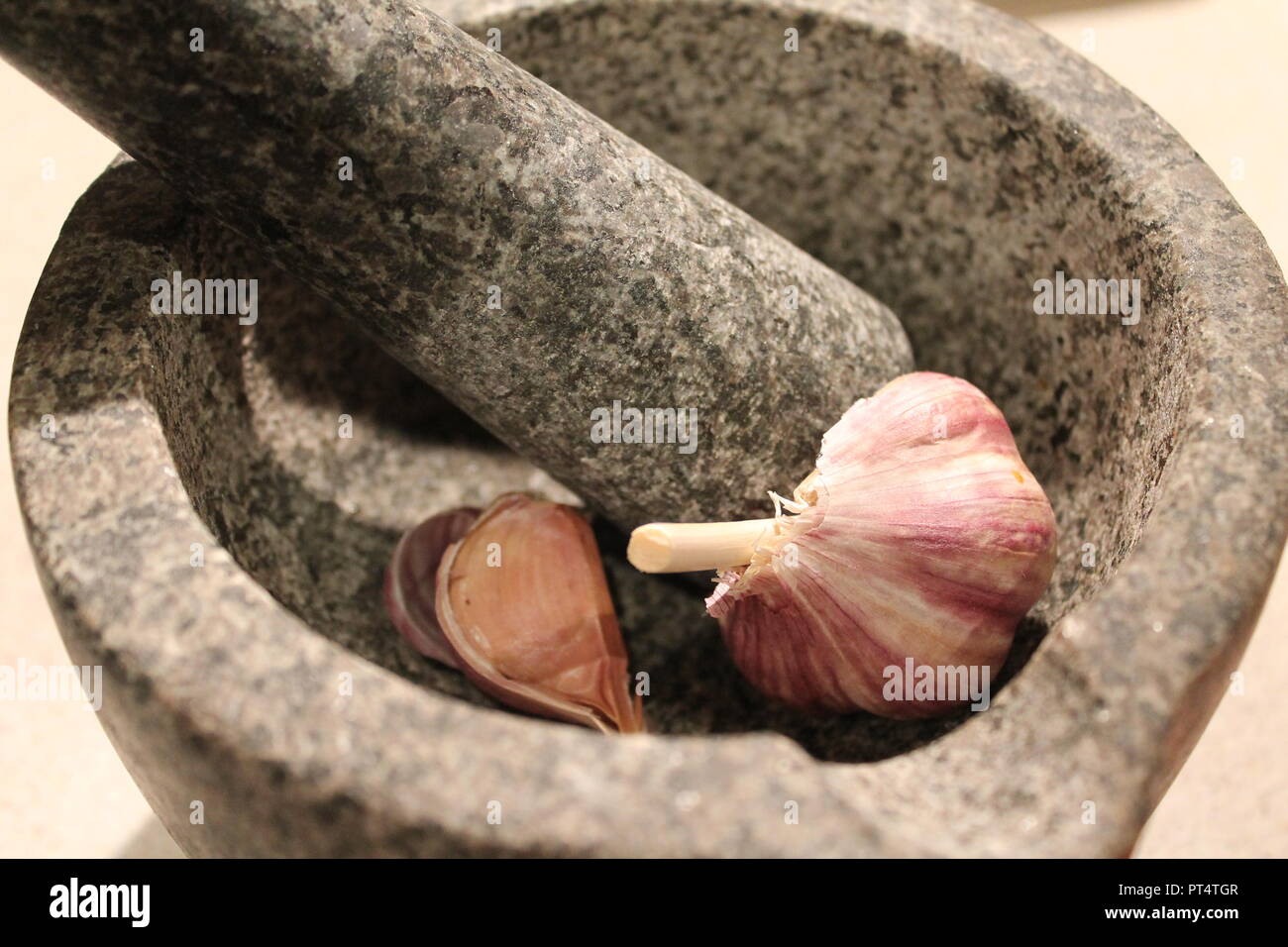 Garlic in pestle and mortar Stock Photo