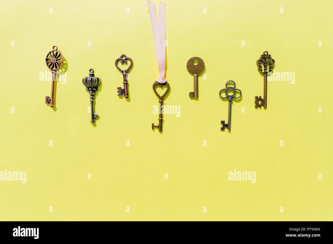 Bunch of keys, steel house keys on yellow background.a lot of different keys isolated.Valentines unlock love concept.Copy space Stock Photo