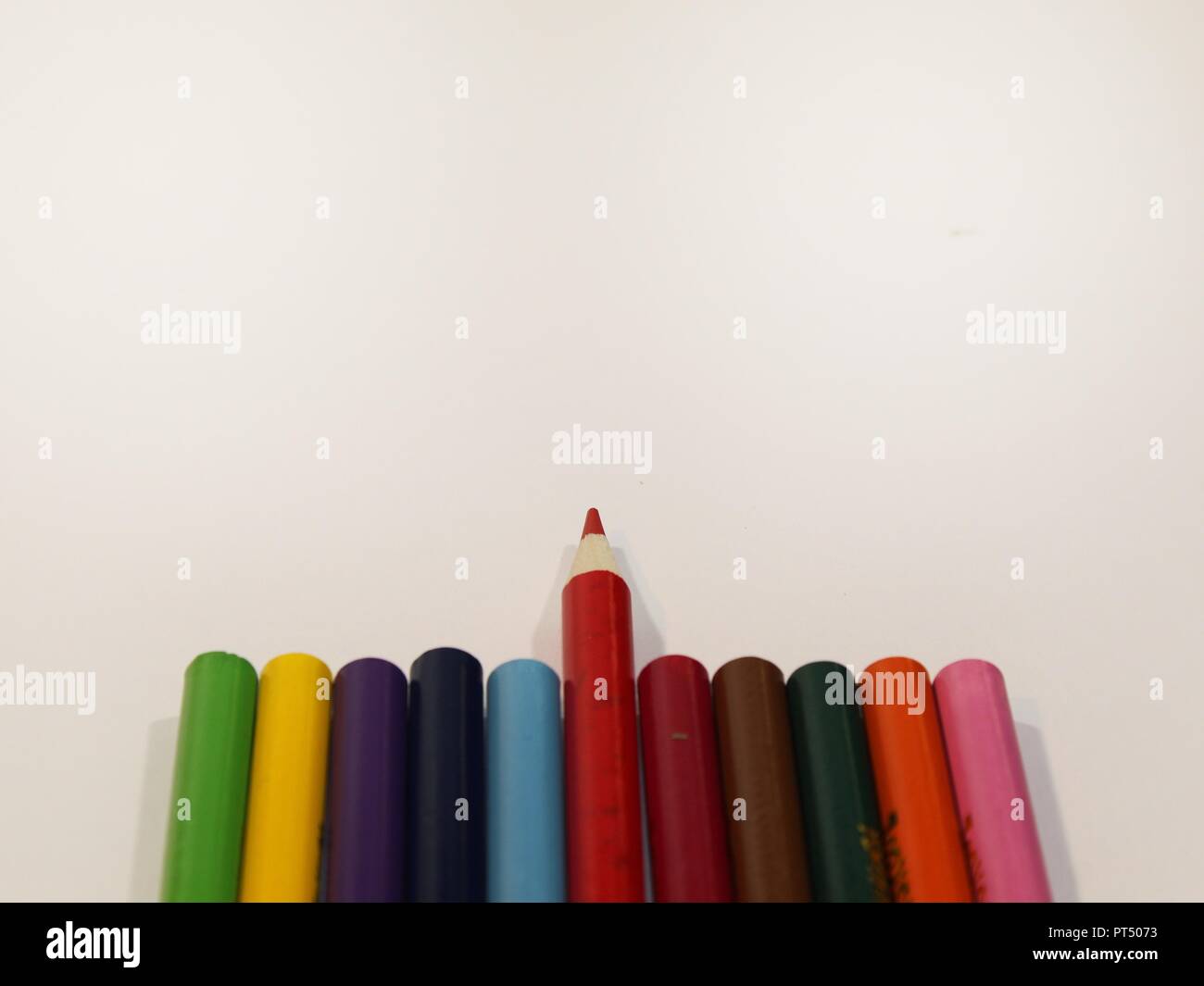 Colored Pencils straight with one solo pencil pointing up Stock Photo