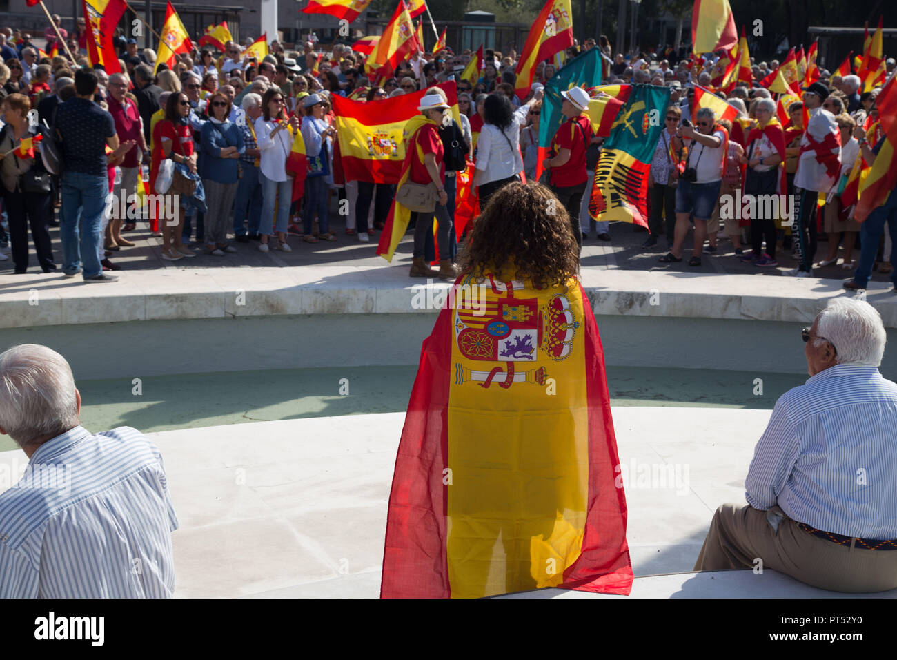 October 6, 2018 - Madrid, Spain - Protester seen covering herself with a flag during the protest..Millions of people with Spanish constitutional and Falangist flags demonstrated in Madrid against the Spanish government of Pedro Sanchez, for the unity of the country and against the inheritance tax. The demonstration stated at the Plaza de ColÃ³n to the Congress of Deputies. (Credit Image: © Lito Lizana/SOPA Images via ZUMA Wire) Stock Photo