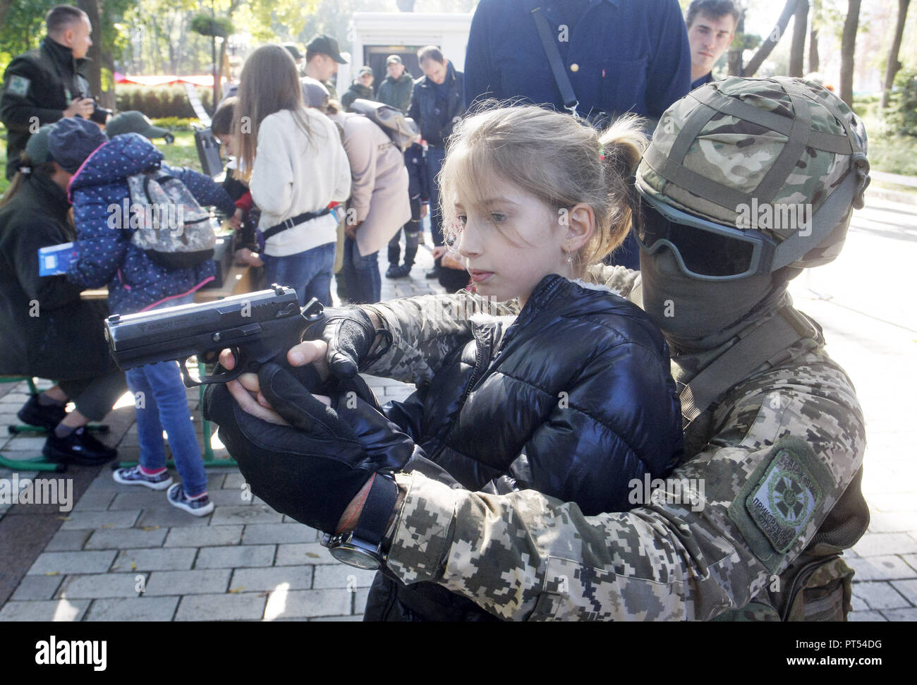 Kiev, Kiev, Ukraine. 6th Oct, 2018. A Ukrainian body guard; serviceman seen showing a little girl a pistol during the festival.City of Professions is a children career-oriented festival that provides children with the opportunity to try themselves in different professions like policemen, doctors, social workers, bankers, criminologists, builders, rescuers, firemen, canine experts, bomb experts, and others professions. Credit: Pavlo Gonchar/SOPA Images/ZUMA Wire/Alamy Live News Stock Photo