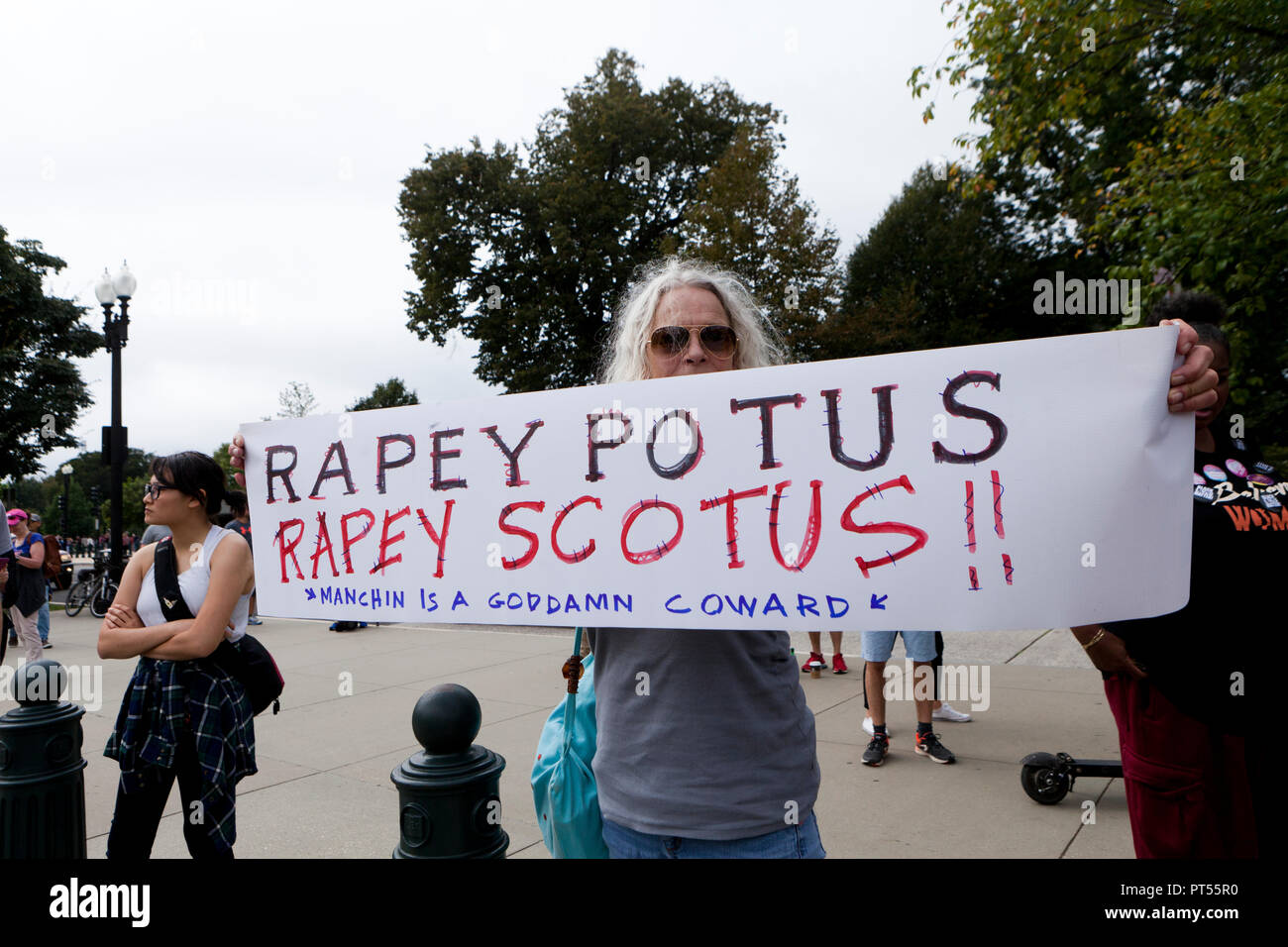 Washington, USA, 6th Oct, 2018: On the day of the final vote to confirm Brett Kavanaugh to the US Supreme Court, thousands of democrat activists protest in front of the Supreme Court building and the US Capitol. Pictured: Woman holding sign suggesting rape by Kavanaugh and Trump.  Credit: B Christopher/Alamy Live News Stock Photo
