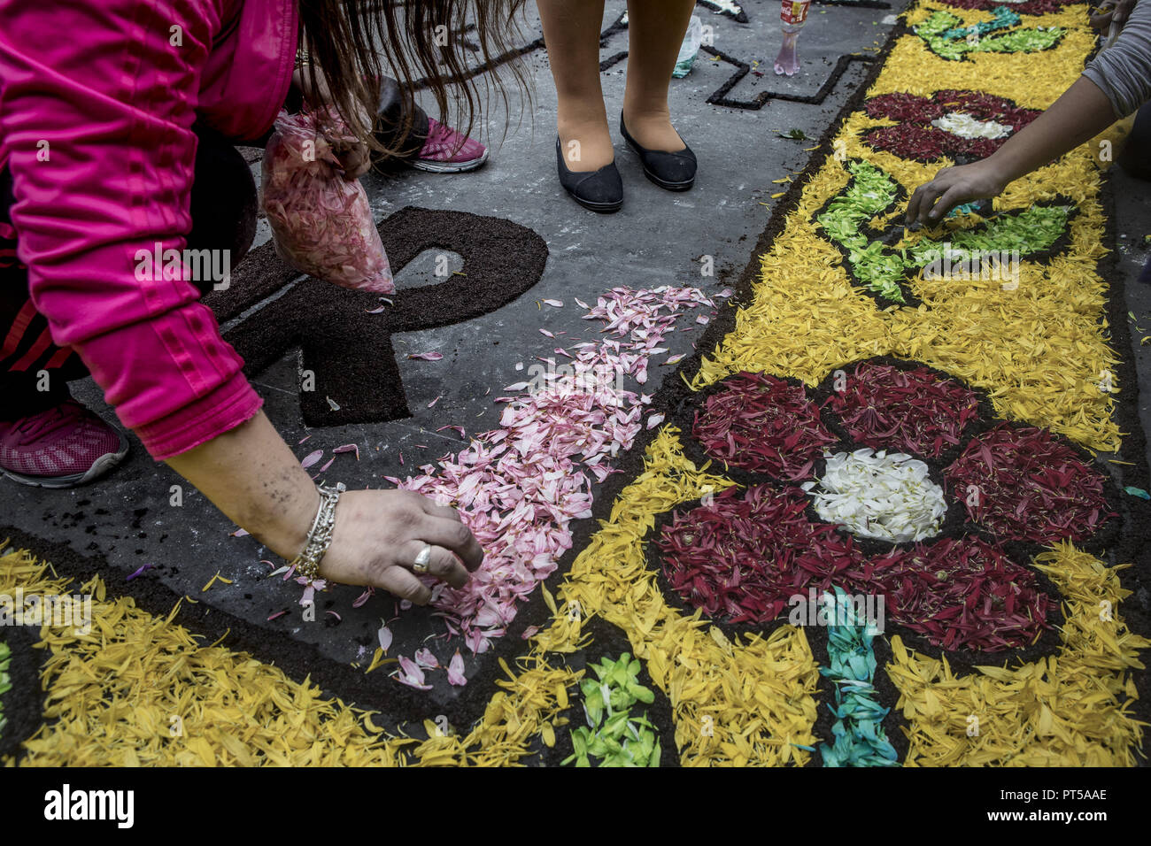 Lima, Peru. 6th Oct, 2018. Devotees making a carpet of flowers, outside the church where the image of the Lord of the Miracles will start the procesion. Every October for the past four centuries this procession takes place in Lima and is known as the most important religious event in Peru. This Peruvian tradition commemorates the devastating 1746 Lima earthquake which left only a mural of Christ standing in a city area. Credit: Guillermo Gutierrez/SOPA Images/ZUMA Wire/Alamy Live News Stock Photo