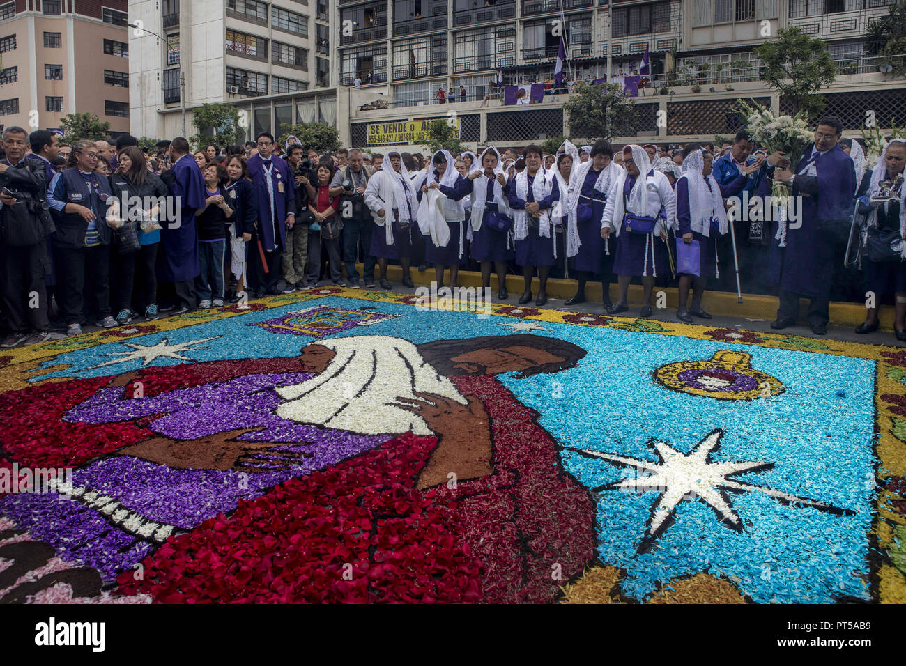 Lima, Peru. 6th Oct, 2018. Devotees making a carpet of flowers, outside the church where the image of the Lord of the Miracles will start the procession. Every October for the past four centuries this procession takes place in Lima and is known as the most important religious event in Peru. This Peruvian tradition commemorates the devastating 1746 Lima earthquake which left only a mural of Christ standing in a city area. Credit: Guillermo Gutierrez/SOPA Images/ZUMA Wire/Alamy Live News Stock Photo