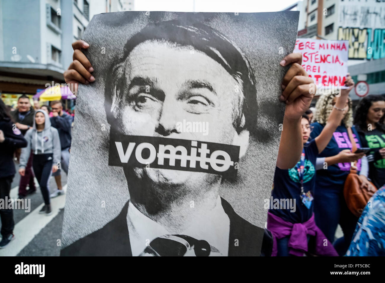 Sao Paulo, Brazil. 06th Oct, 2018. A woman holds up an anti-Bolsonaro poster at a demonstration against the presidential candidacy of far-right politician of Jair Bolsonaro on October 6, 2018. The sign translates as "vomit". (Credit: Pablo Albarenga/dpa) Credit: Pablo Albarenga/dpa/Alamy Live News Stock Photo