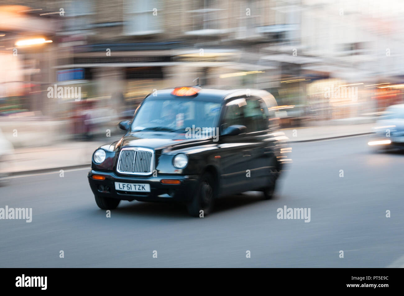 Moving London black cab taxi in street Stock Photo