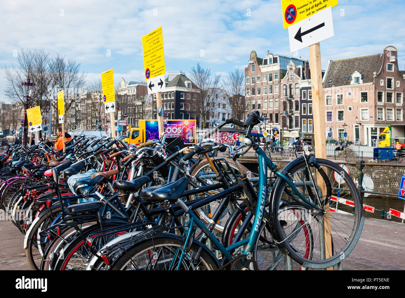 Bunch of bicycles parked next to the canal at Old Central district in Amsterdam Stock Photo